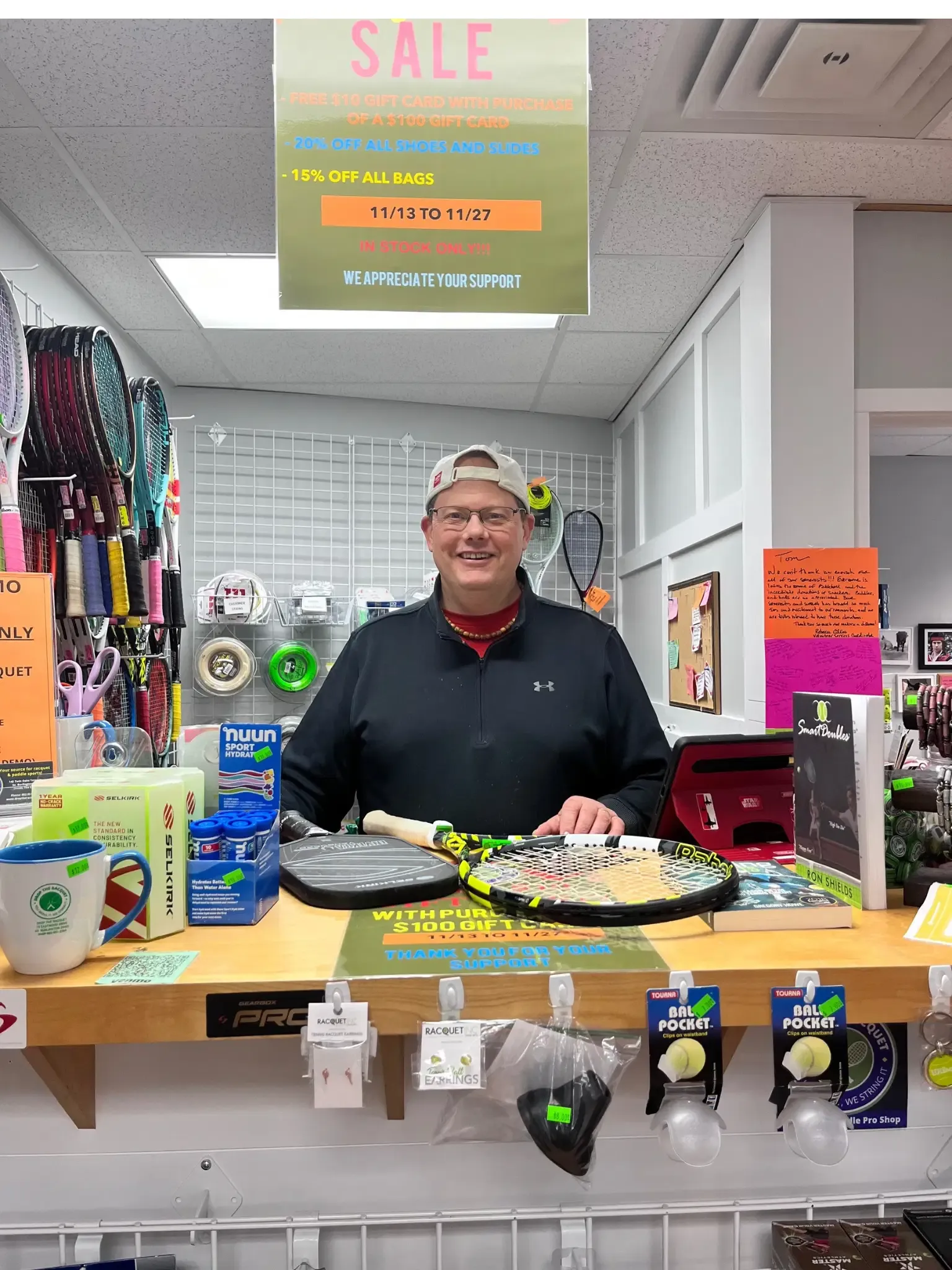 Drop the Racquet owner helping from behind the shop counter